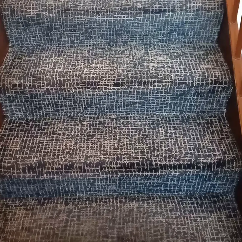 A grey and white patterned stair carpet