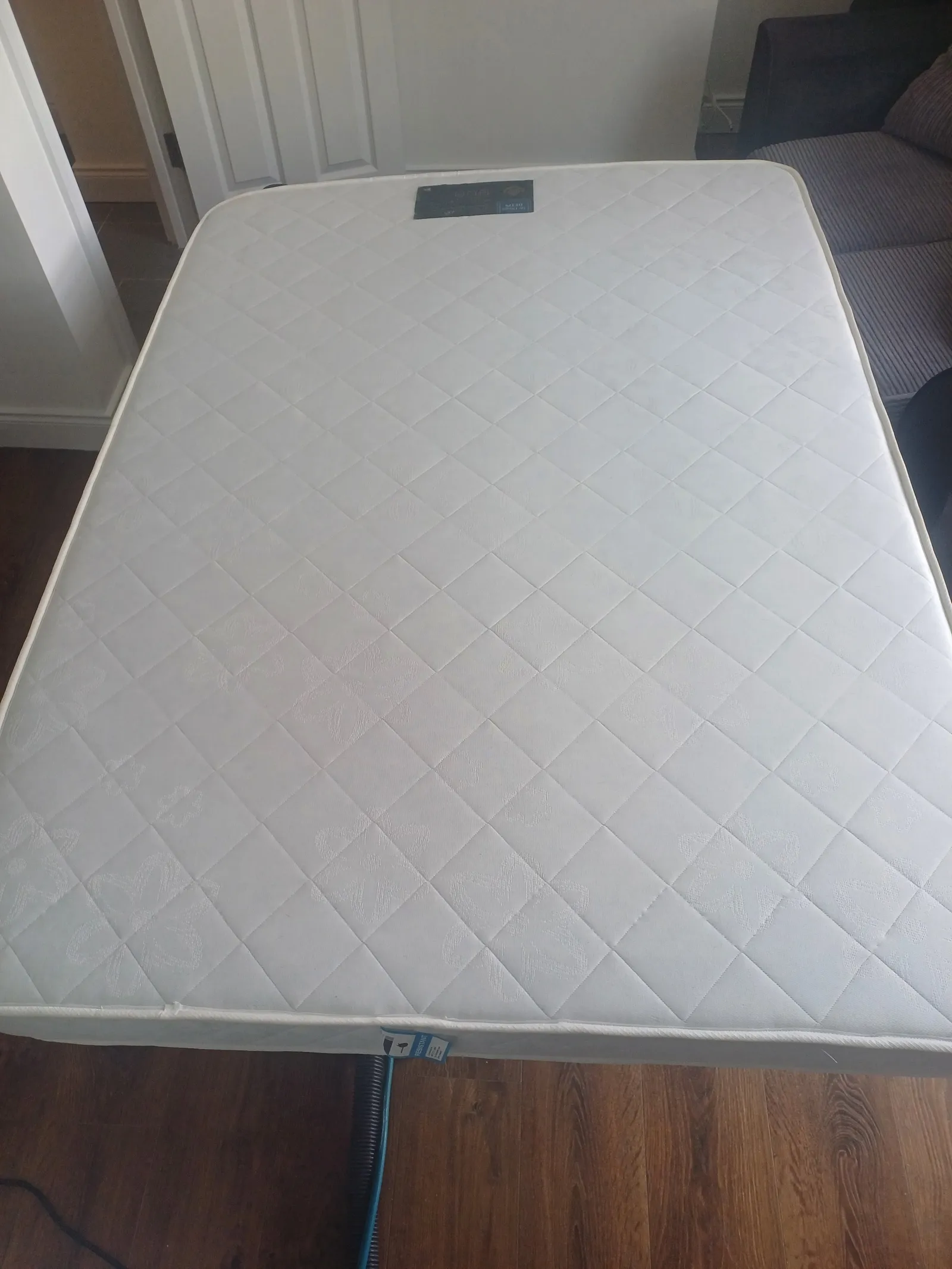 Mattress being cleaned with an extraction hose attached